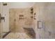 Luxurious shower featuring travertine tile, built-in shelves, and modern fixtures for a spa-like experience at 2398 Bitterroot Ln, Golden, CO 80401