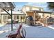 House's backyard features a deck, pergola, and a snowy landscape at 8478 Prairie Clover Way, Parker, CO 80134