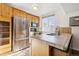 Kitchen with stainless steel refrigerator and light wood cabinets at 8478 Prairie Clover Way, Parker, CO 80134