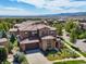 Stunning aerial view of a luxury home with a tiled roof, manicured landscaping, and mountain views at 2256 S Isabell Ct, Lakewood, CO 80228