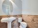 Charming powder room featuring pedestal sink, tile accent wall, and oval mirror at 2256 S Isabell Ct, Lakewood, CO 80228