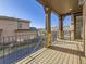 Covered outdoor patio featuring wood beams, stone pillars, and black metal railing overlooking backyard at 2256 S Isabell Ct, Lakewood, CO 80228