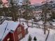 Aerial view of snow covered mountain home with a fenced yard and surrounding trees at 102 S High St, Breckenridge, CO 80424