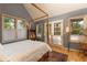 Bedroom featuring several large windows, French doors, hardwood flooring, and a wooden-framed four-poster bed at 102 S High St, Breckenridge, CO 80424