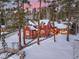 Charming red home with snow-covered roof and landscape, adjacent guest house, and a colorful sunset at 102 S High St, Breckenridge, CO 80424