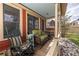 Covered porch with rocking chairs and wicker sofa with stone foundation and red house at 102 S High St, Breckenridge, CO 80424