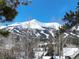 Stunning mountain view through sparse Aspen trees and rooftops, clear blue skies, winter wonderland at 102 S High St, Breckenridge, CO 80424