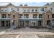 View of townhouse complex with stone facade, neutral paint, and small rock landscaping at 452 Black Feather Loop # 606, Castle Rock, CO 80104