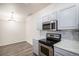 Modern kitchen with a stainless steel microwave and oven, light colored cabinets, and stylish backsplash at 452 Black Feather Loop # 606, Castle Rock, CO 80104