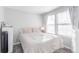 Bright bedroom with neutral tones featuring a queen bed, large window, and natural light at 1128 S Ventura Cir # B, Aurora, CO 80017