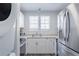 Bright kitchen featuring stainless steel appliances, white cabinets, and a stacked laundry at 1128 S Ventura Cir # B, Aurora, CO 80017