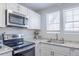 Bright kitchen featuring white cabinetry, stainless steel appliances, and granite countertops at 1128 S Ventura Cir # B, Aurora, CO 80017