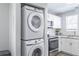 Stacked laundry machines next to a modern kitchen with stainless steel appliances at 1128 S Ventura Cir # B, Aurora, CO 80017