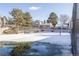Snow-covered tennis court reflects nearby homes, perfect for recreational activities within the community at 1128 S Ventura Cir # B, Aurora, CO 80017