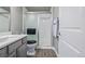 Modern bathroom with a white tile shower, gray walls, gray vanity and wood-look floors at 11884 Barrentine Loop, Parker, CO 80138