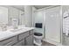 Modern bathroom features a vanity with a gray cabinet, a shower, and neutral-colored walls at 11884 Barrentine Loop, Parker, CO 80138