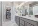 Bright bathroom featuring a double vanity with marble countertop and a door to the walk in closet at 11884 Barrentine Loop, Parker, CO 80138