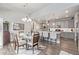 Open-concept dining room features a glass table, modern chandelier, and flows into the kitchen with bar seating at 11884 Barrentine Loop, Parker, CO 80138