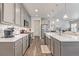 Well-lit kitchen features gray cabinets, stainless steel appliances, a large island, and an open concept design at 11884 Barrentine Loop, Parker, CO 80138