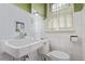 Vintage-style bathroom with classic white tile, toilet, and sink, creating a timeless appeal at 134 S 5Th Ave, Brighton, CO 80601