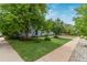 Property with a well-kept lawn, mature trees, and an inviting entrance, complemented by a concrete sidewalk at 134 S 5Th Ave, Brighton, CO 80601
