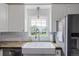 Bright kitchen boasts a farmhouse sink, white subway tile backsplash, and stainless steel appliances at 134 S 5Th Ave, Brighton, CO 80601