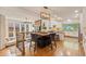 Open-concept dining area with island, modern lighting, and seamless flow to the kitchen at 6874 Raspberry Run, Littleton, CO 80125