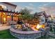 Outdoor fire pit with stone surround and seating, perfect for entertaining at 6874 Raspberry Run, Littleton, CO 80125