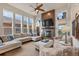 Open concept living room featuring a fireplace, large windows, and cozy seating area with natural light at 6874 Raspberry Run, Littleton, CO 80125