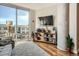 Sunlit living area featuring a large window, modern shelving, and a cozy sofa with hardwood floors at 4200 W 17Th Ave # 611, Denver, CO 80204