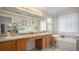 Bright bathroom featuring dual sinks, natural wood cabinets and a soaking tub at 22778 E Alamo Ln, Aurora, CO 80015