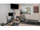 Home gym features a treadmill, rowing machine, weights, and mounted television at 22778 E Alamo Ln, Aurora, CO 80015