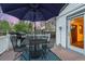 Outdoor deck area features a table, chairs, grill, and blue patterned rug under a large blue umbrella at 2666 S Green Ct, Denver, CO 80219