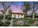 Charming single story home featuring beautiful landscaping with mature trees and flowering plants at 2666 S Green Ct, Denver, CO 80219