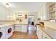 Kitchen with white cabinets, butcher block countertops, terra cotta tile floors, and laundry appliances at 2666 S Green Ct, Denver, CO 80219