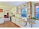 Kitchen with white cabinets, butcher block countertops, terra cotta tile floors, and adjacent living area at 2666 S Green Ct, Denver, CO 80219