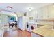 Kitchen with white cabinets, butcher block countertops, terra cotta tile floors, and laundry appliances at 2666 S Green Ct, Denver, CO 80219
