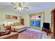 A living room with a ceiling fan, sliding glass doors, and light-colored walls and flooring at 2666 S Green Ct, Denver, CO 80219
