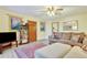 Inviting living room featuring a comfortable couch, ottoman, and stylish decor, illuminated by a ceiling fan and natural light at 2666 S Green Ct, Denver, CO 80219