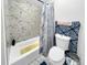Updated bathroom with a bathtub, marble style tiling and blue accent shower curtain at 3782 S Genoa Cir # A, Aurora, CO 80013