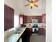 Well-equipped kitchen with dark cabinets, granite countertops, and stainless steel appliances under vaulted ceiling at 3782 S Genoa Cir # A, Aurora, CO 80013