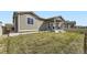 Exterior view showcasing the home's backyard, featuring a well-maintained lawn and a cozy covered patio at 10555 Boston St, Commerce City, CO 80640