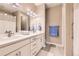 Modern bathroom with double sinks, white cabinets, and stylish lighting fixtures at 10555 Boston St, Commerce City, CO 80640