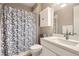 Well-lit bathroom featuring a shower with patterned curtain, a white cabinet and matching vanity at 10555 Boston St, Commerce City, CO 80640