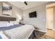 Comfortable bedroom with soft bedding, accent art, mounted TV, and convenient access to the adjoining bathroom at 10555 Boston St, Commerce City, CO 80640