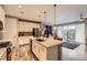 Open kitchen layout with island, stainless appliances, and living area access to the patio at 10555 Boston St, Commerce City, CO 80640