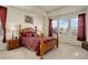 Primary bedroom with a large window, tray ceiling, and a wooden bed frame at 1265 Black Haw St, Elizabeth, CO 80107