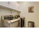 Well-equipped laundry room with front-loading washer and dryer and storage cabinets at 1265 Black Haw St, Elizabeth, CO 80107