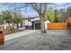 Driveway next to a home showcasing gray gravel, a wooden fence, and an attached garage at 11172 W Exposition Dr, Denver, CO 80226