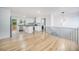 Open concept featuring hardwood floors, white kitchen cabinets, island and modern staircase at 11172 W Exposition Dr, Denver, CO 80226